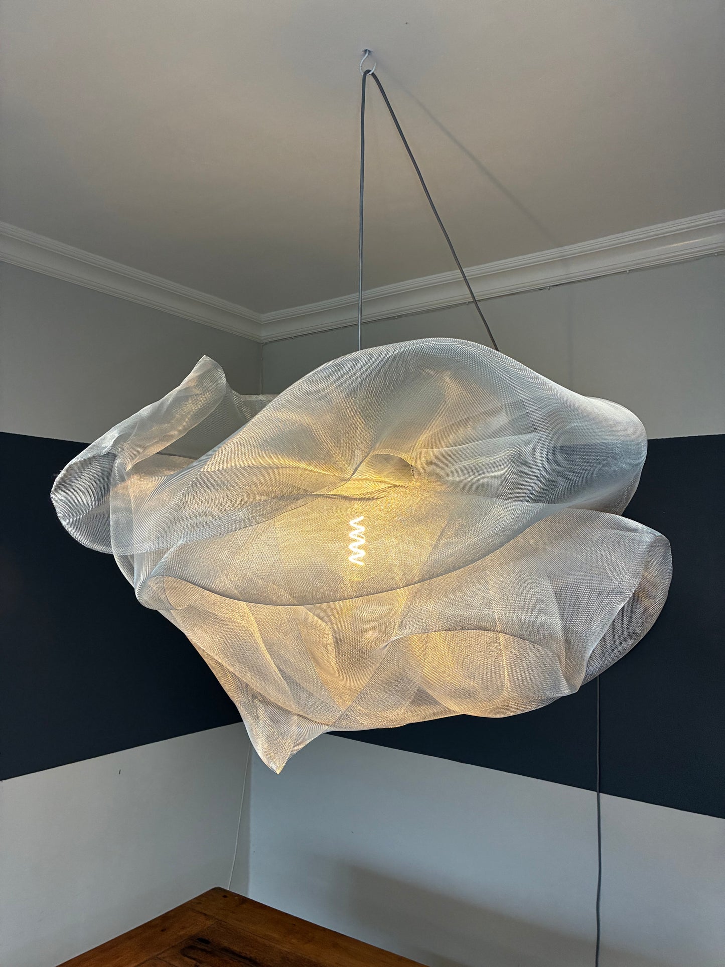 Side view of the Industrial Mesh Pendant suspended above a dining table