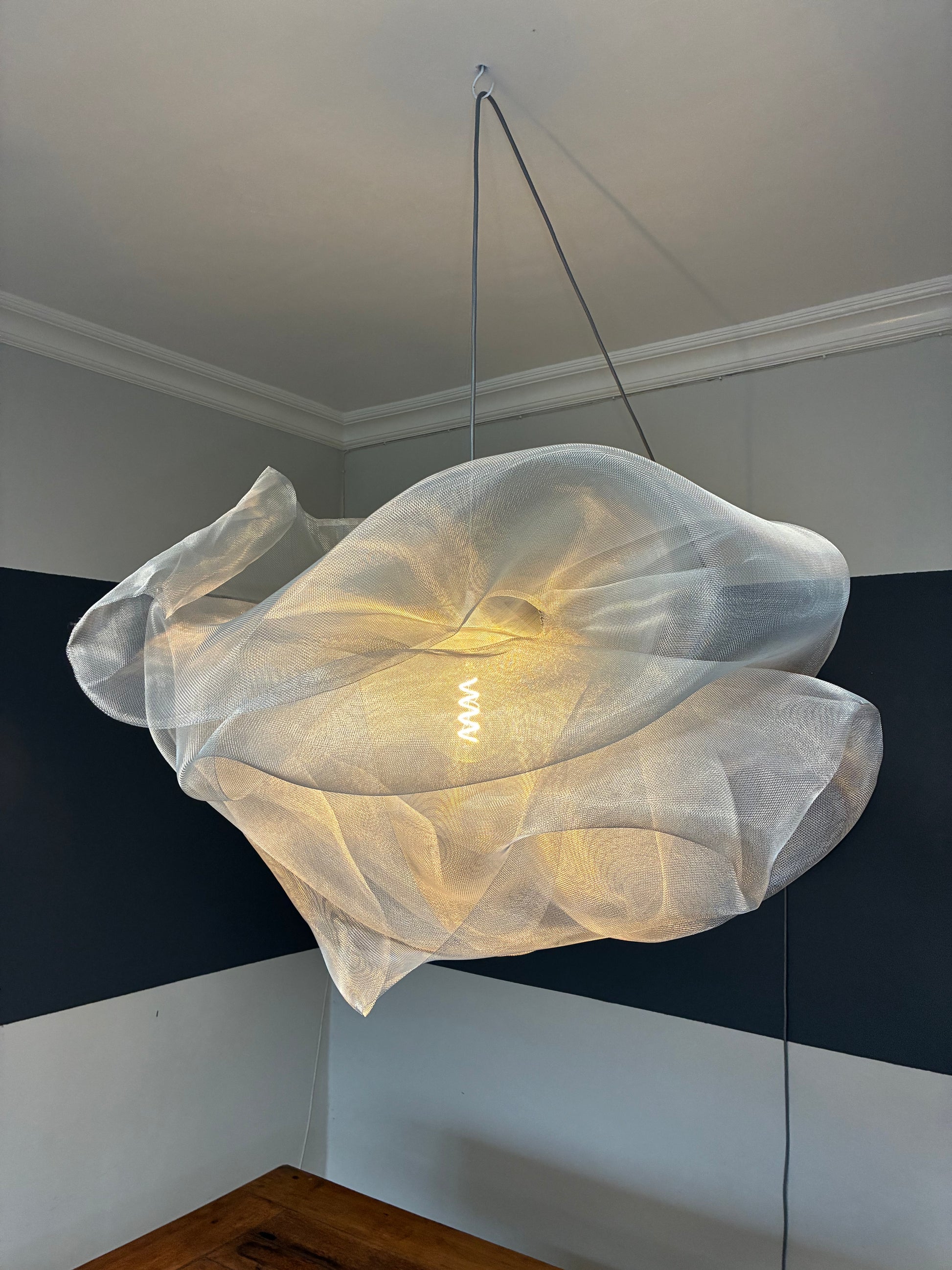 Side view of the Industrial Mesh Pendant suspended above a dining table