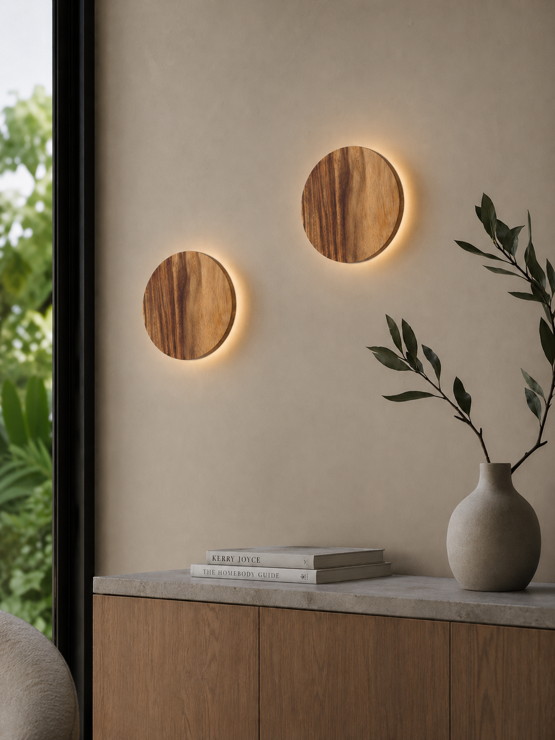 Illuminated Namibian Teak Circle Wall Lights creating warm ambient lighting beside a window